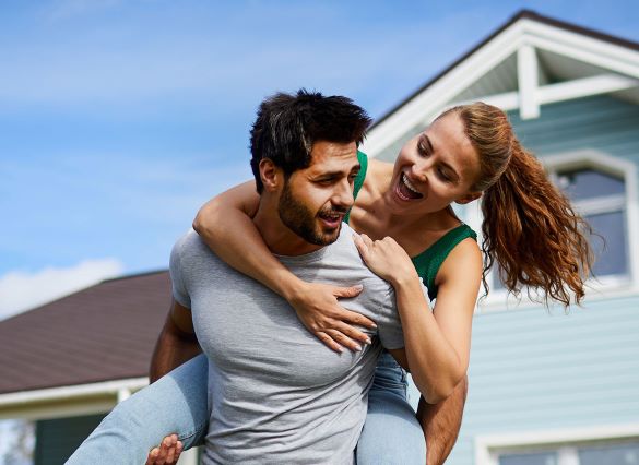 happy couple in front of their home