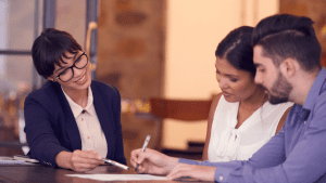 A couple consulting with woman about an auto refinance