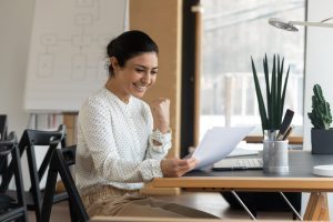 a woman smiles happily after meeting all of her credit union's personal loan requirements and getting approved