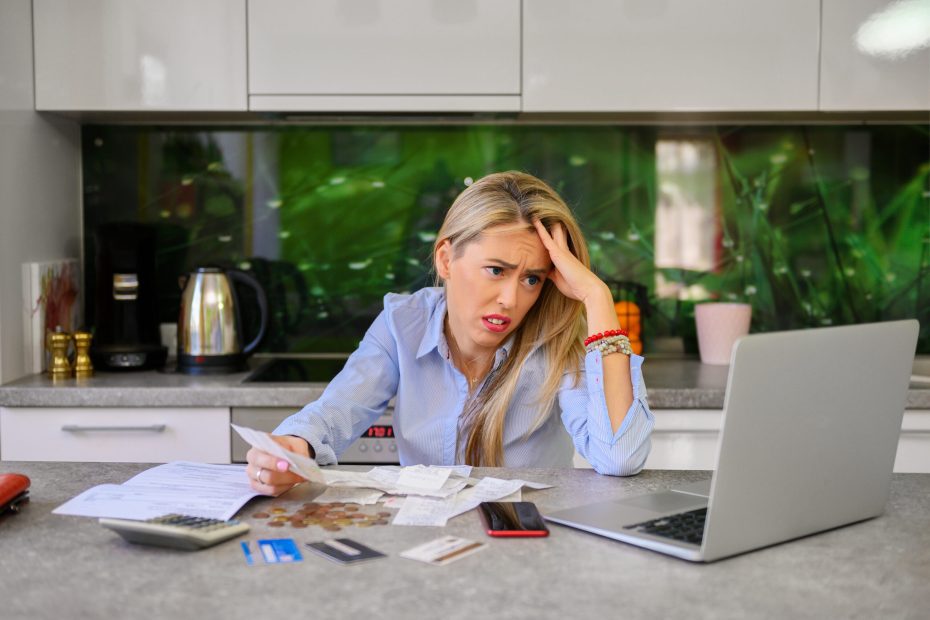 an overwhelmed woman goes through her credit card debt and bills deciding between a payday loan vs. personal loan to cover it all