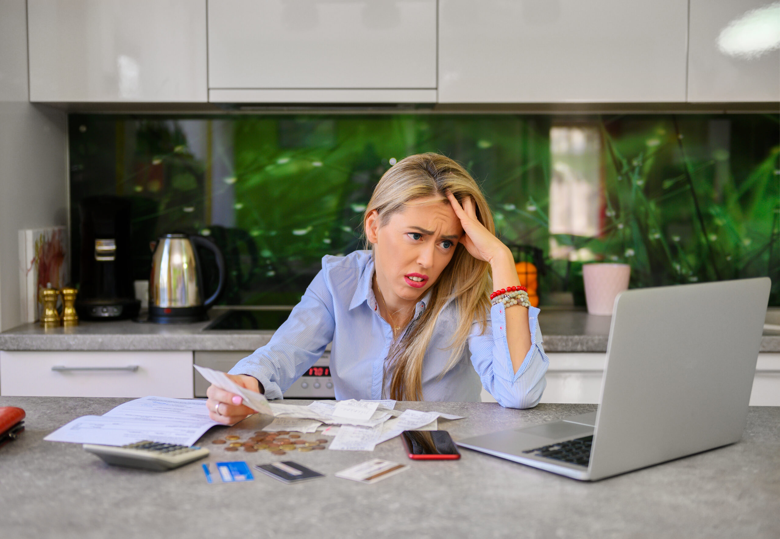 an overwhelmed woman goes through her credit card debt and bills deciding between a payday loan vs. personal loan to cover it all