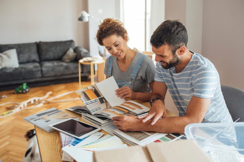 a couple looks at samples and swatches, planning their renovation after buying a fixer-upper home