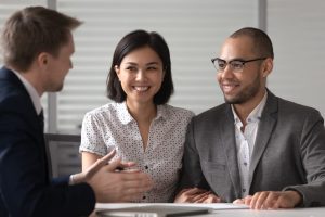 A smiling couple discusses personal loan FAQs with a credit union representative.