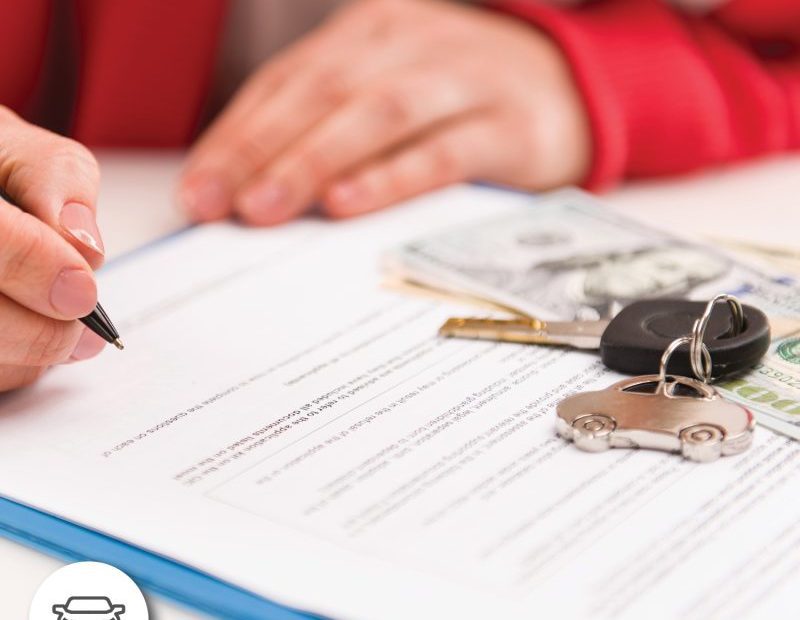 An individual signing an auto loan application.